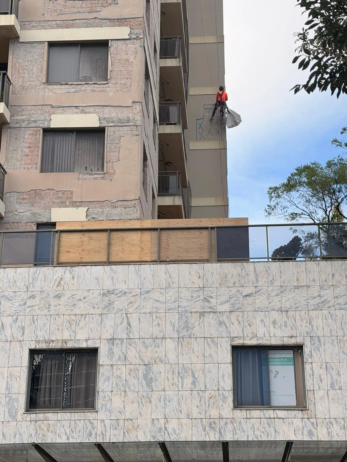 Rope access technician near the top of a Bankstown residential tower during remedial works