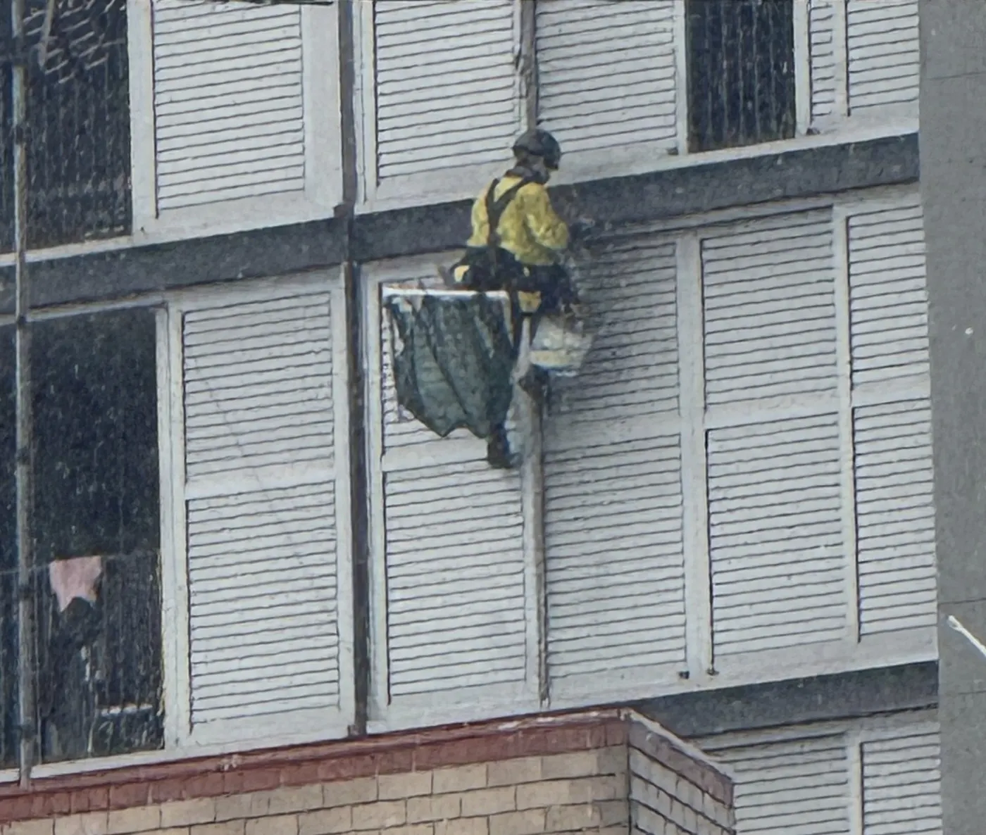 Building maintenance on rope beside the louvred windows of a Randwick hotel