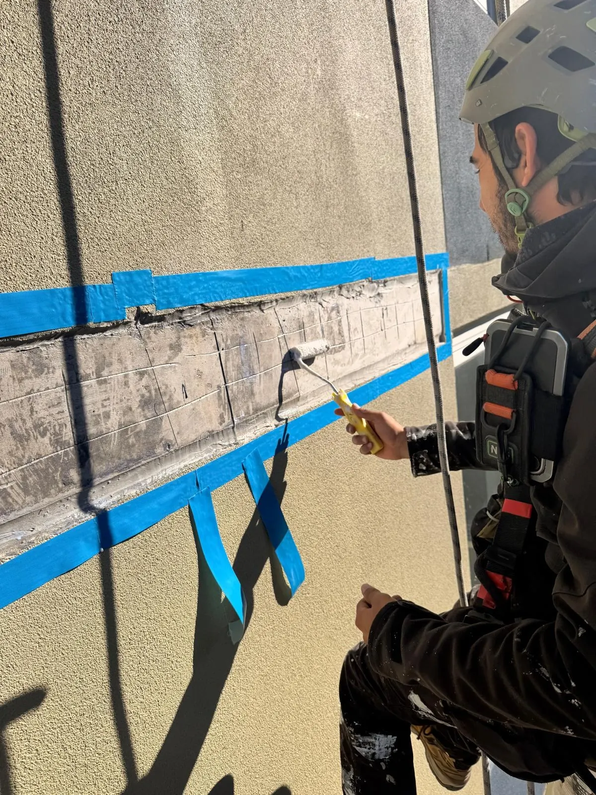 Bonding primer rolled onto the prepared slab edge before the render repair